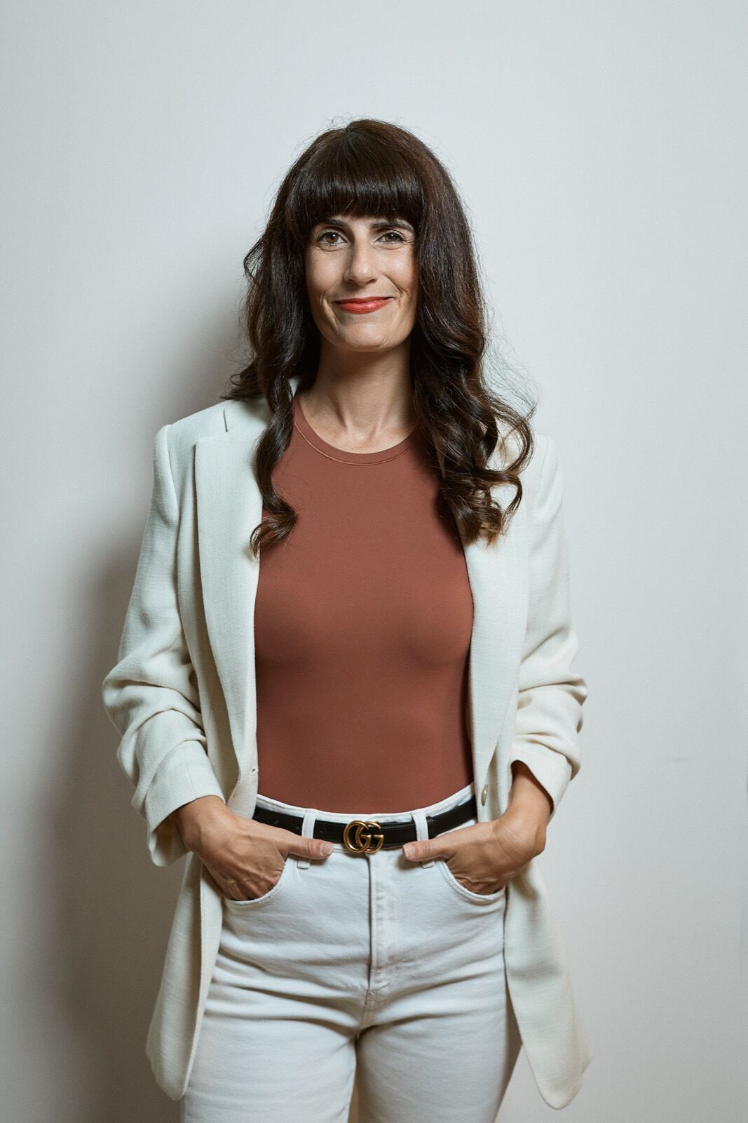 Elvira Häusler im cremefarbenen Anzug vor hellem Hintergrund.